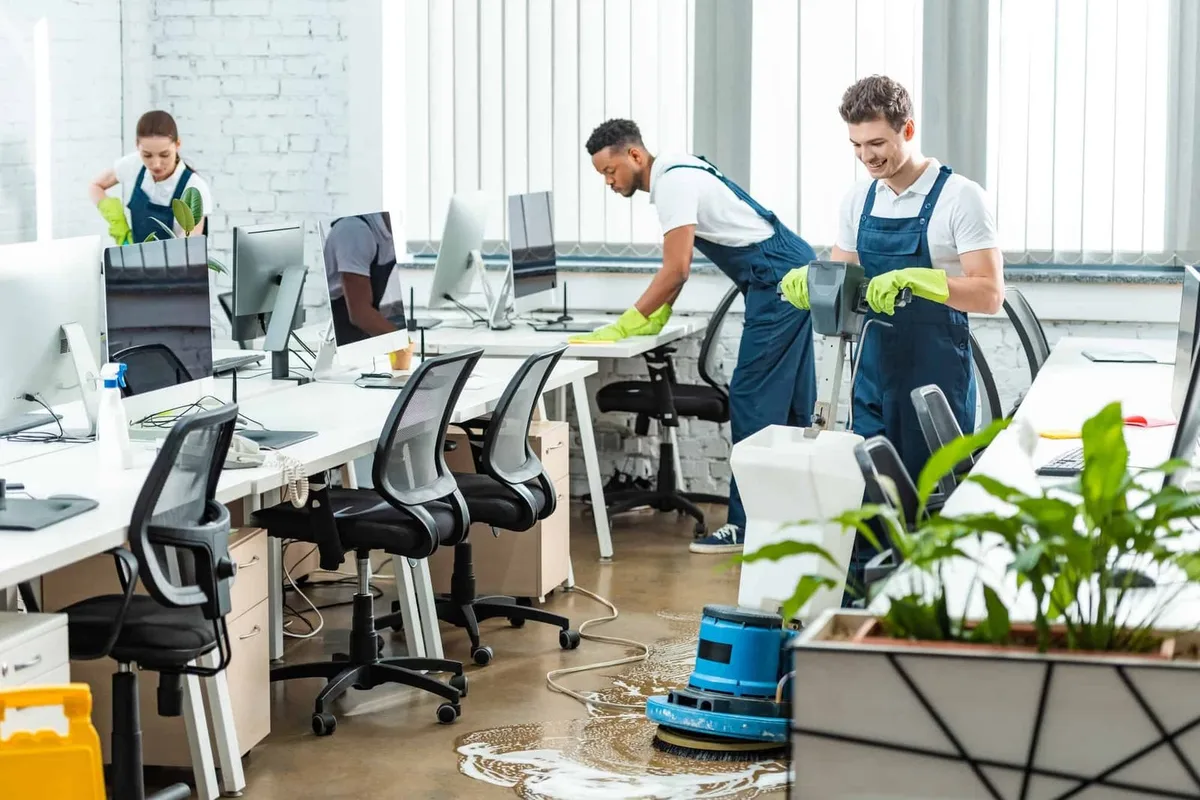 A cleaning team working across a modern open-plan office