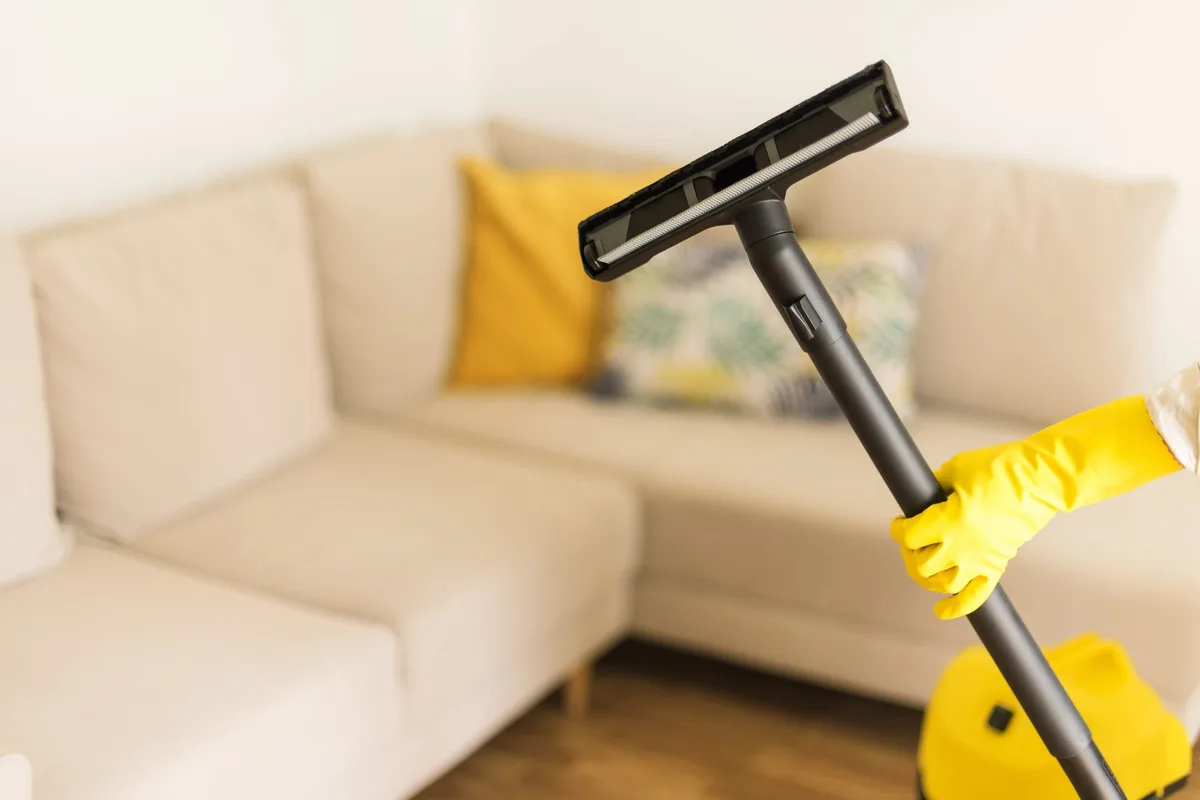 Vacuuming a bright living room in yellow cleaning gloves