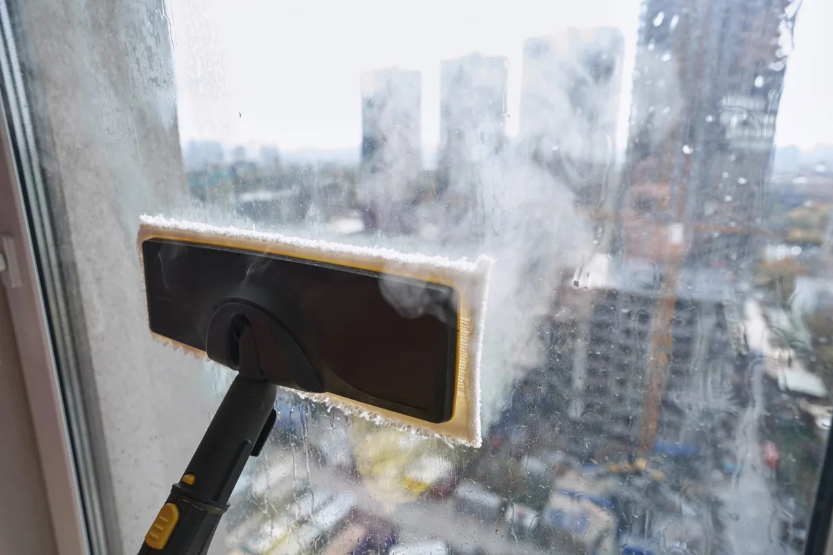 Steam-cleaning a high-rise window above the Vancouver skyline