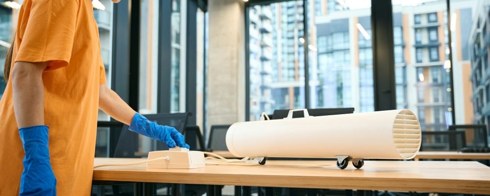 Employee cleaning company uses ozone generator while cleaning in coworking space