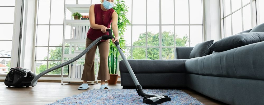 Housemaid using vacuum machine cleaning carpet
