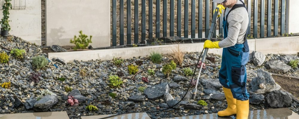 Man Pressure Washing Concrete Tiles